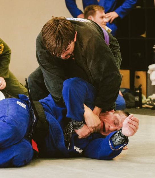 Purple belt finishing a collar choke from top position