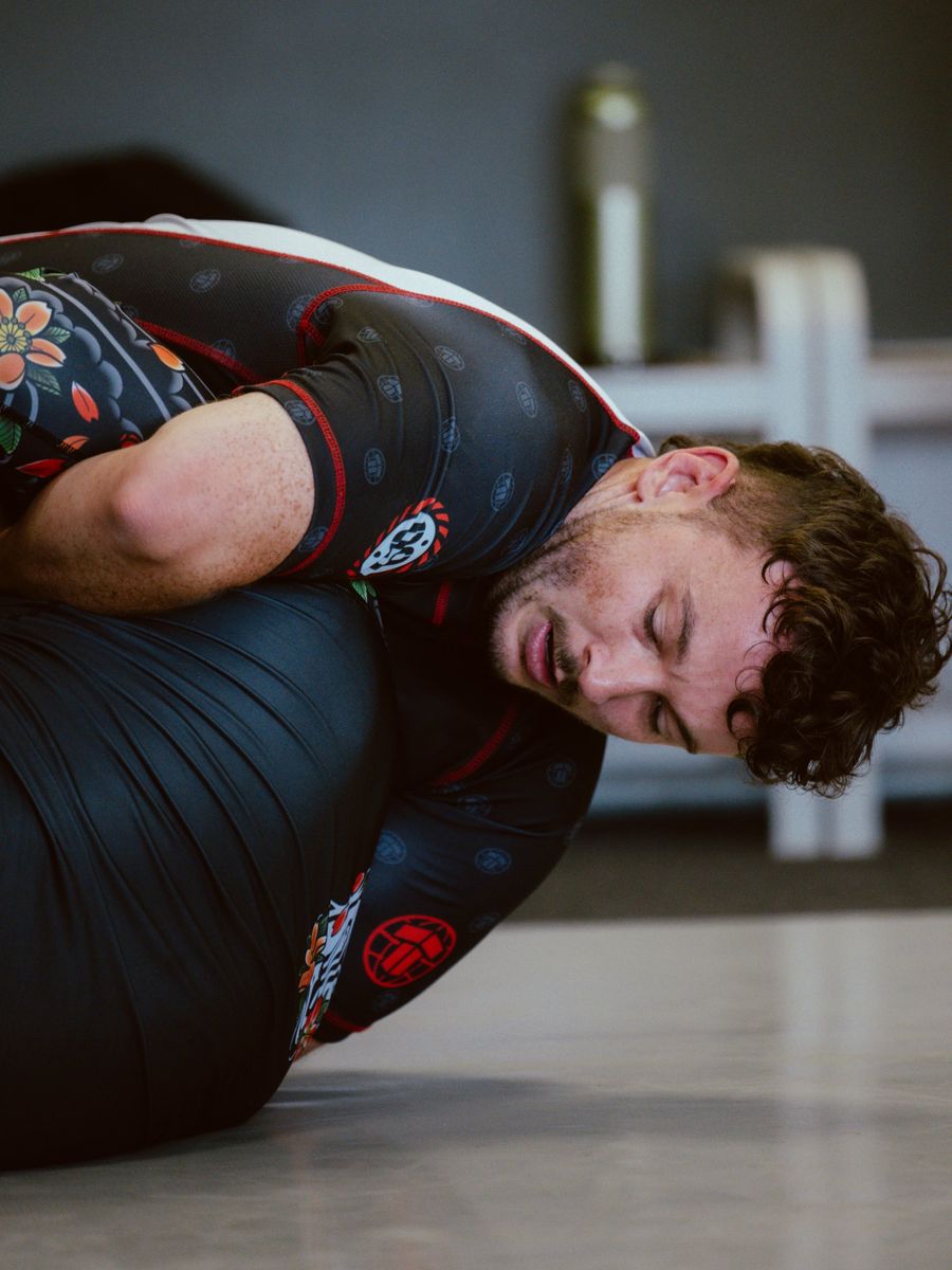 Student in a rash guard working for a front headlock during No-Gi